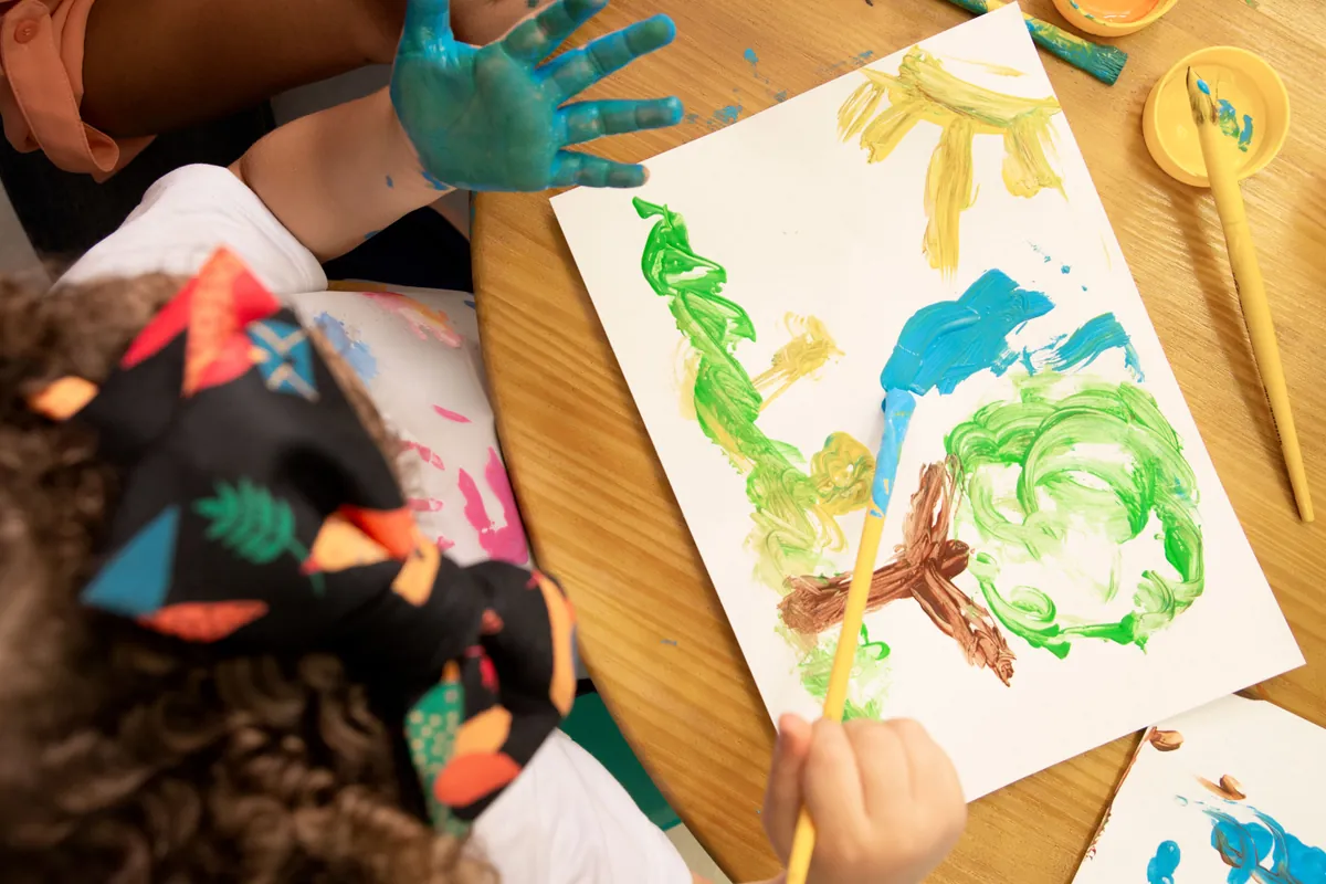 Young children finger-painting together at a bright early learning centre, captured by Sprint Marketing.